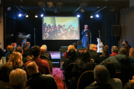 Eine Bühne mit vollem Saal, Publikum von Hinten Lilli Berger Founder of VYVYT und farvel dem ersten virutellen 3D Erinnerungsraum